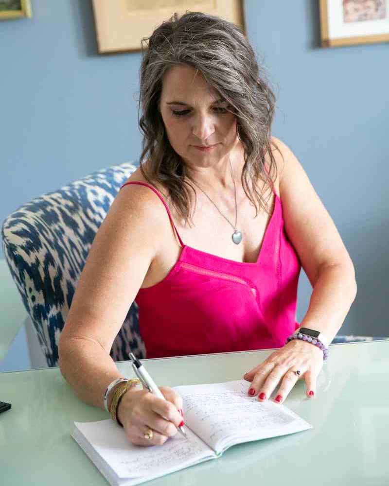 Megon Moore Inc. | Megan Moore writing in office.